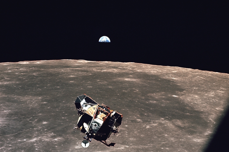 View of NASA Apollo lander with Moon in background and Earth in distance